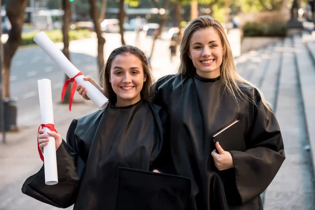 Two IVF nurse graduates with gowns and smiling face.